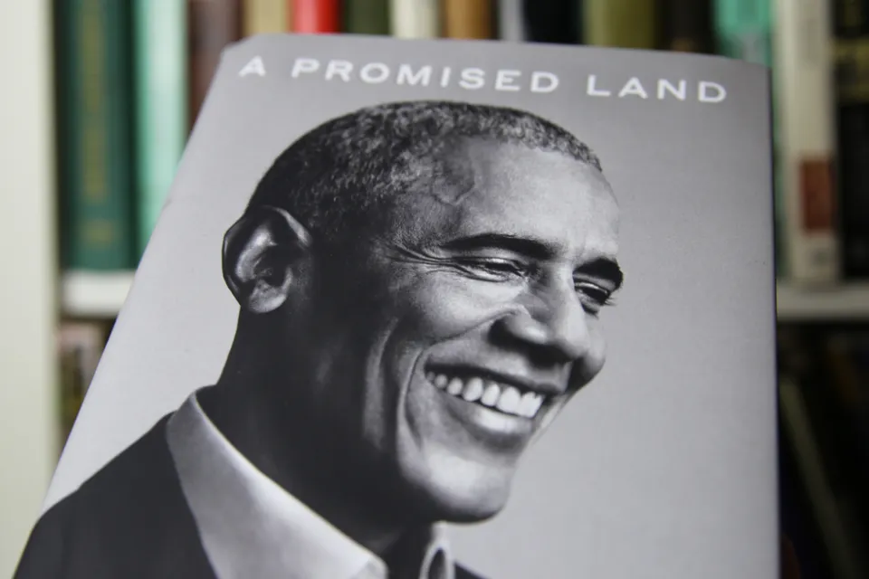An image of the book "A Promised Land," by Barack Obama shows a black and white photo of the former president smiling.